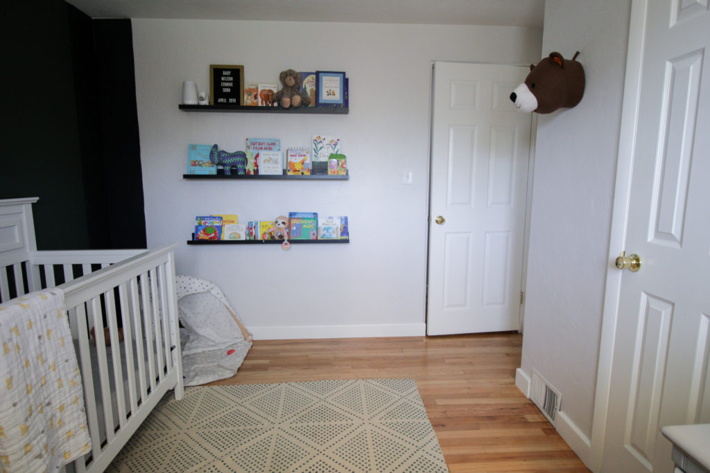 Image of a decorated nursery featuring a bookshelf wall made of picture ledges.